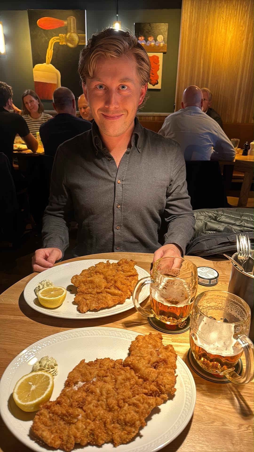 A diner with plates of schnitzel and mugs of beer at Sidepour